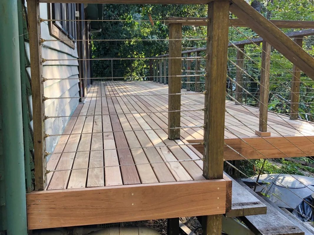 A Wooden Deck With Stairs and a Wire Railing — Byron Bay Carpentry and Construction In Suffolk Park, NSW
