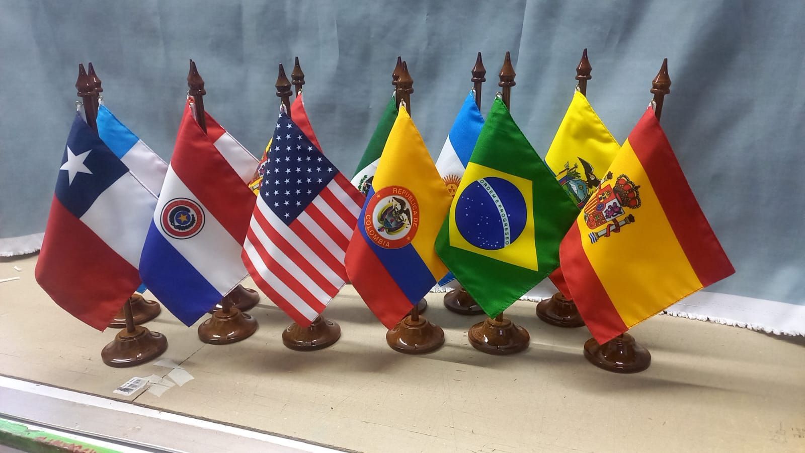 Row of small desk flags from several countries on stands, including Chile, Paraguay, USA, Ecuador, Brazil, and Spain