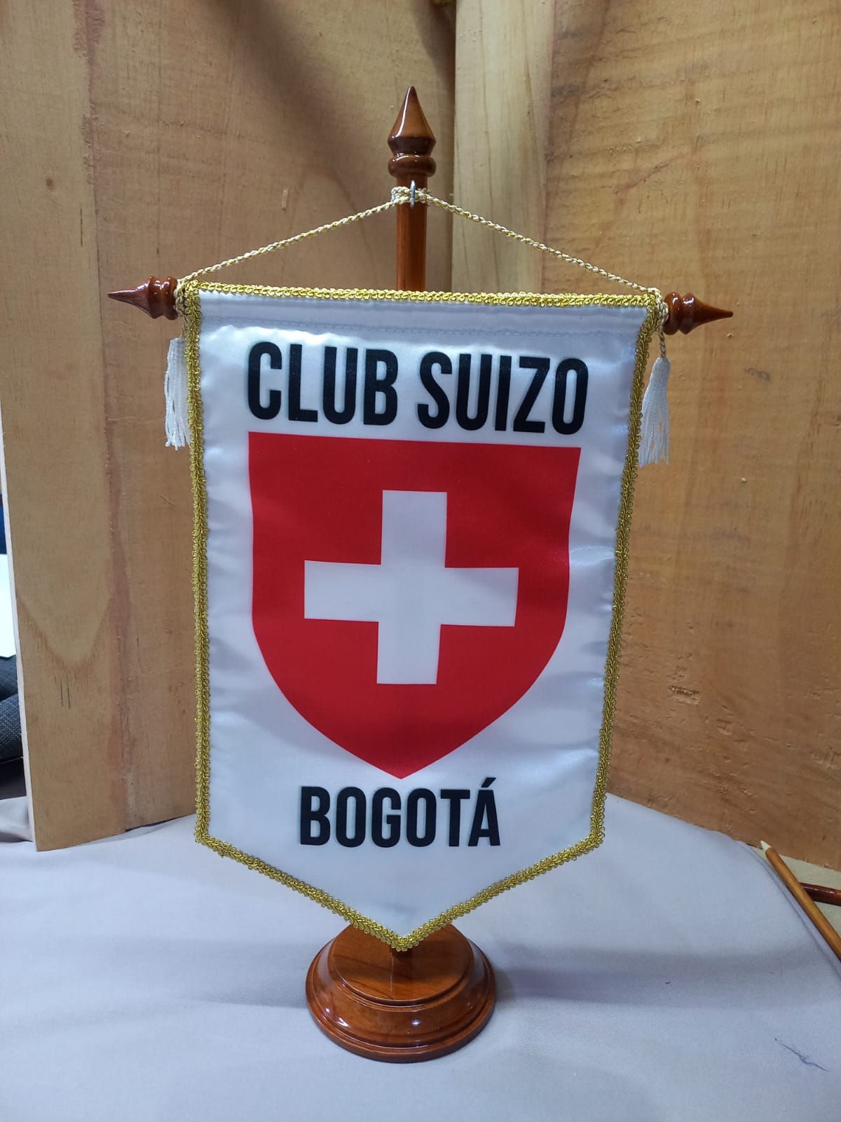 Club Suizo Bogotá banner with Swiss shield emblem on a small gold stand