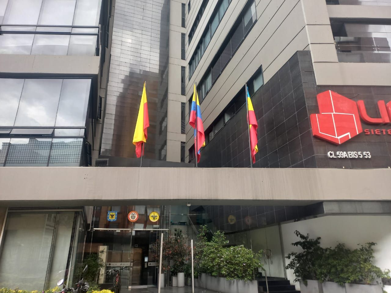 Modern building entrance with hanging flags and a black sign reading “U” and “CLUBS”