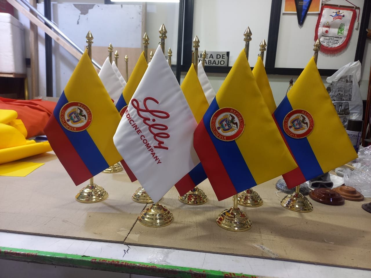 Small tabletop display of Ecuador flags and a white “Señor” flag on gold stands indoors