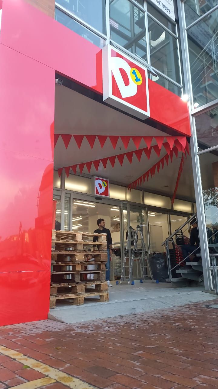 Storefront with a bright pink facade, open entrance, and shelves visible inside.