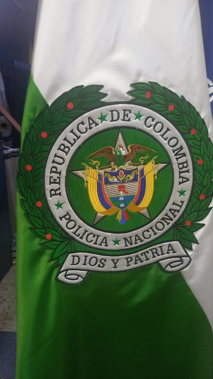 Green-and-white Colombian National Police flag with emblem and “Policía Nacional” text
