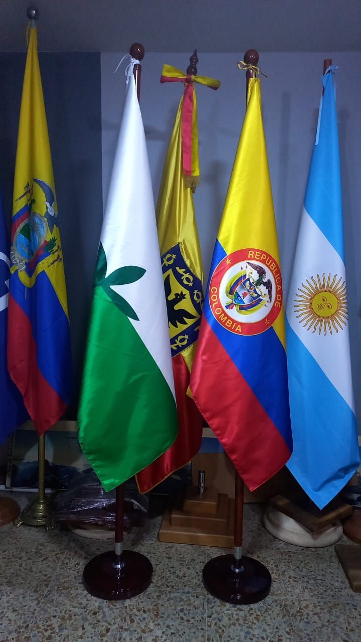 Five standing flags indoors, including Colombia, Bulgaria, Costa Rica, and Argentina.