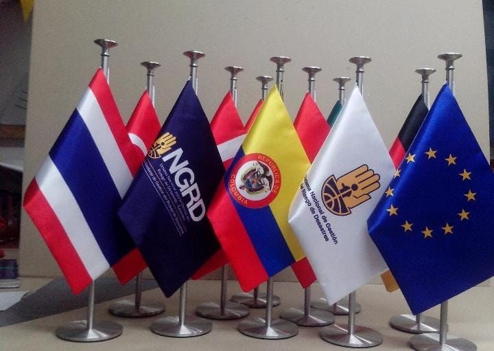 Five desktop flags, including Thailand, NATO, and the EU, standing in a row