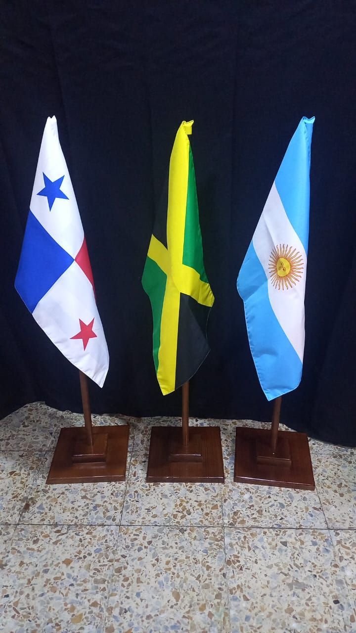 Three tabletop flags on stands: Panama, Jamaica, and Argentina against a dark background.