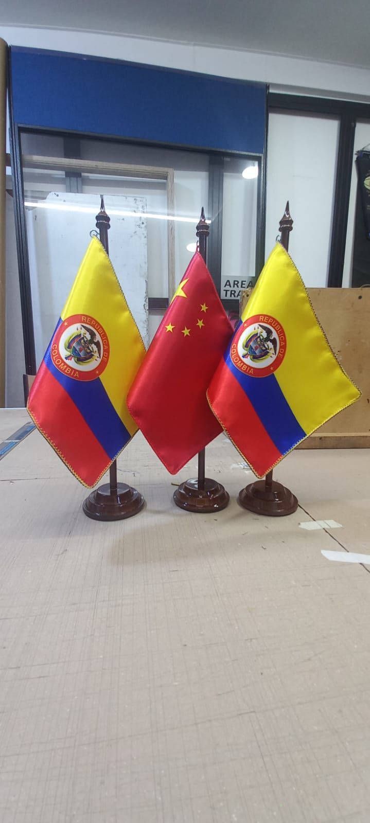 Three Ecuador flags on small stands on a table in an office setting