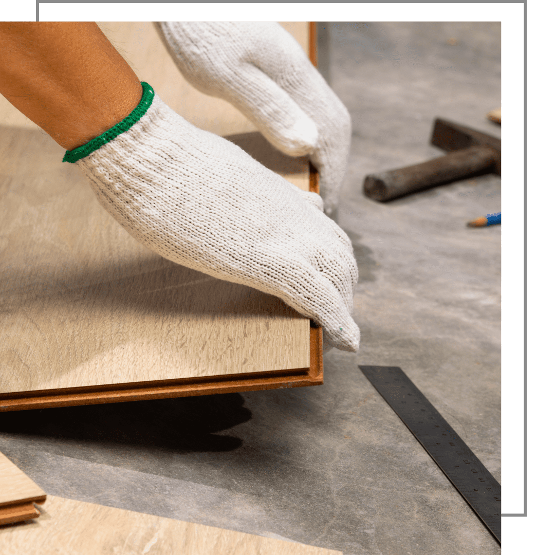 Gloved hands aligning a wooden board on a workbench during a woodworking project