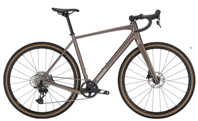 Vélo gravel marron avec guidon route et pneus beiges, vu de profil sur fond blanc