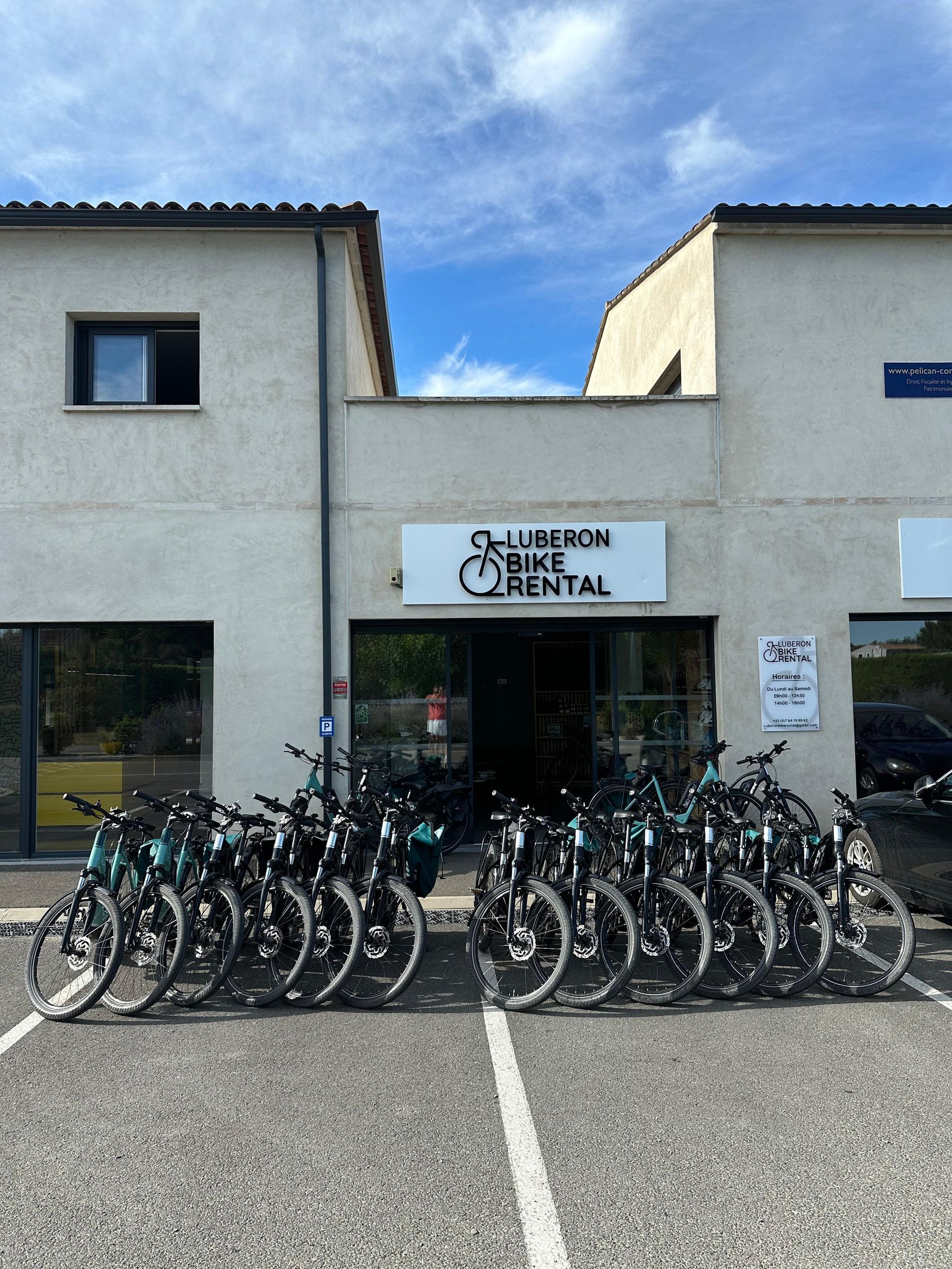 Des vélos étaient alignés devant un bâtiment blanc portant une pancarte indiquant « LOCATION DE TULIPAN ».