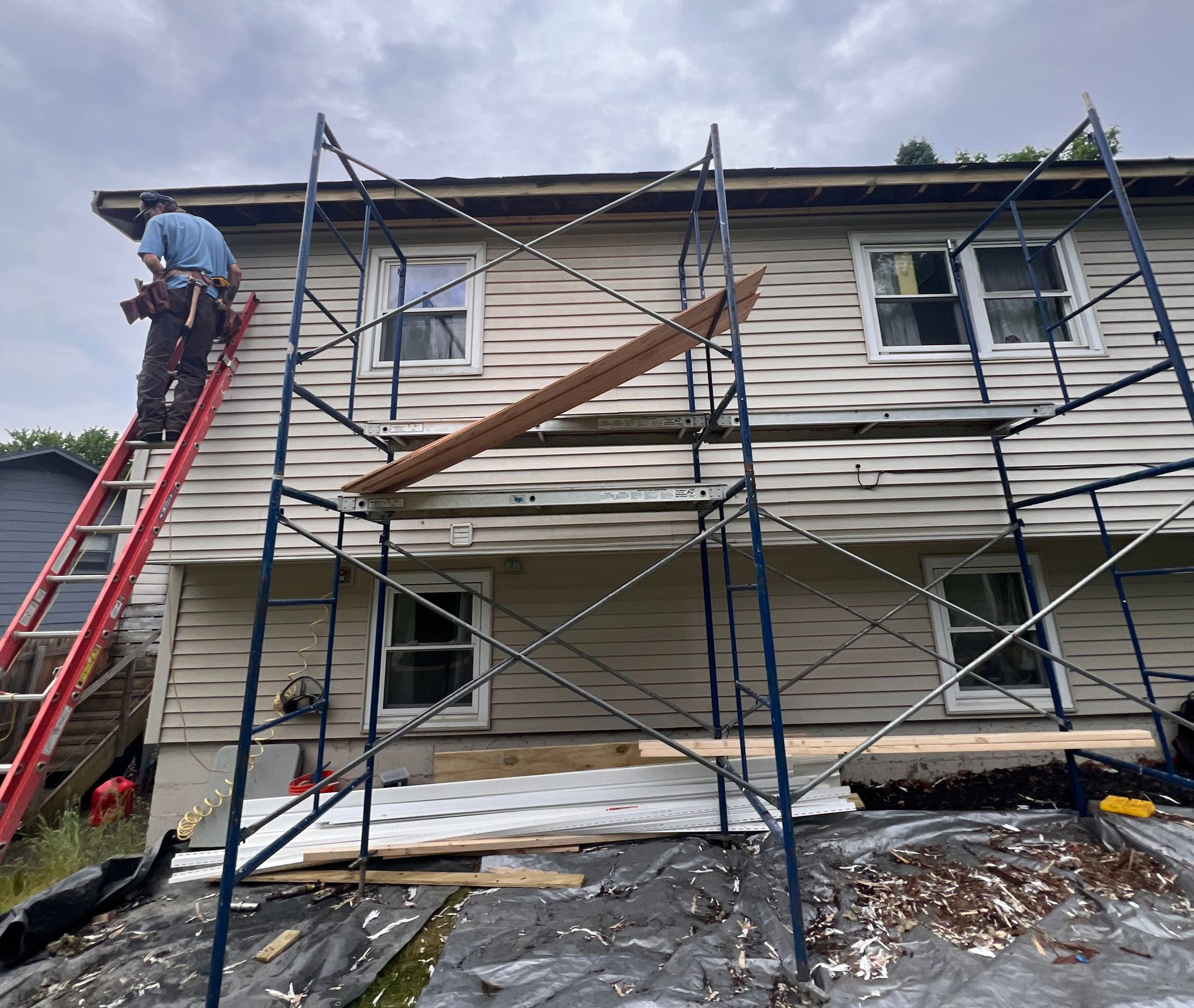 Lawn care technician mowing a Vermont residential property
