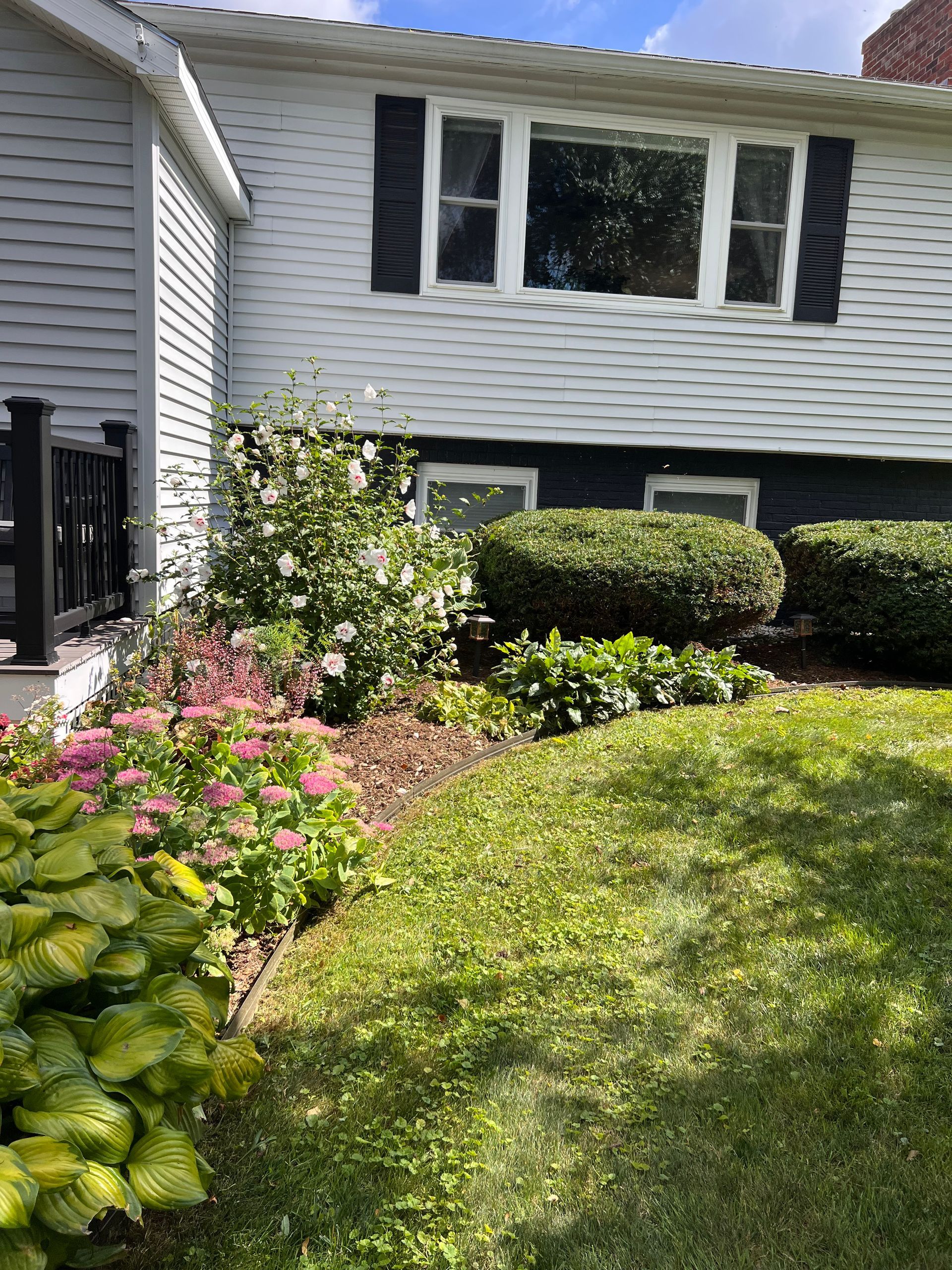 Well-kept Vermont yard in early spring with tools staged