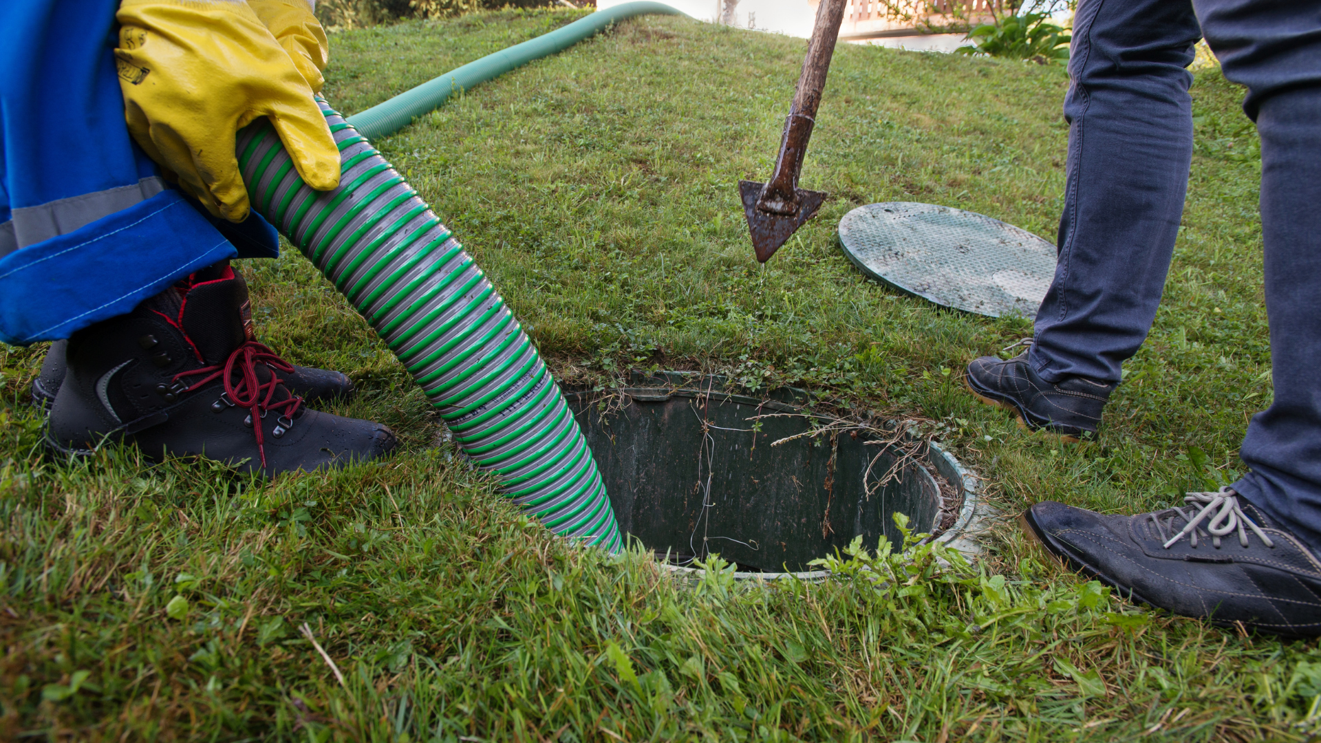 Person digging in a dirt trench beside cinder blocks and tools in a yard.