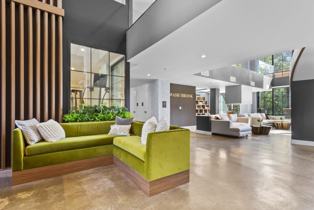 Modern lobby with lime-green lounge seating, wood slat wall, and open airy interior