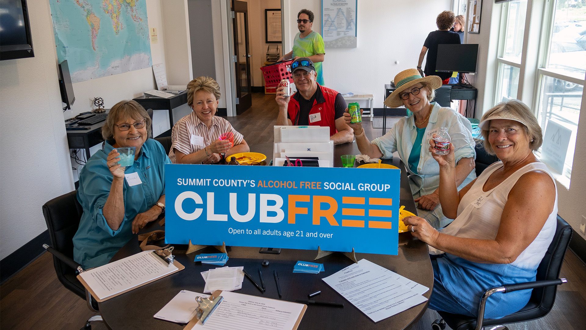 Image of a group of people sitting a a table enjoying pie and drinks at a Clubfree event.