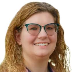 Woman with blonde hair and teal glasses smiling.