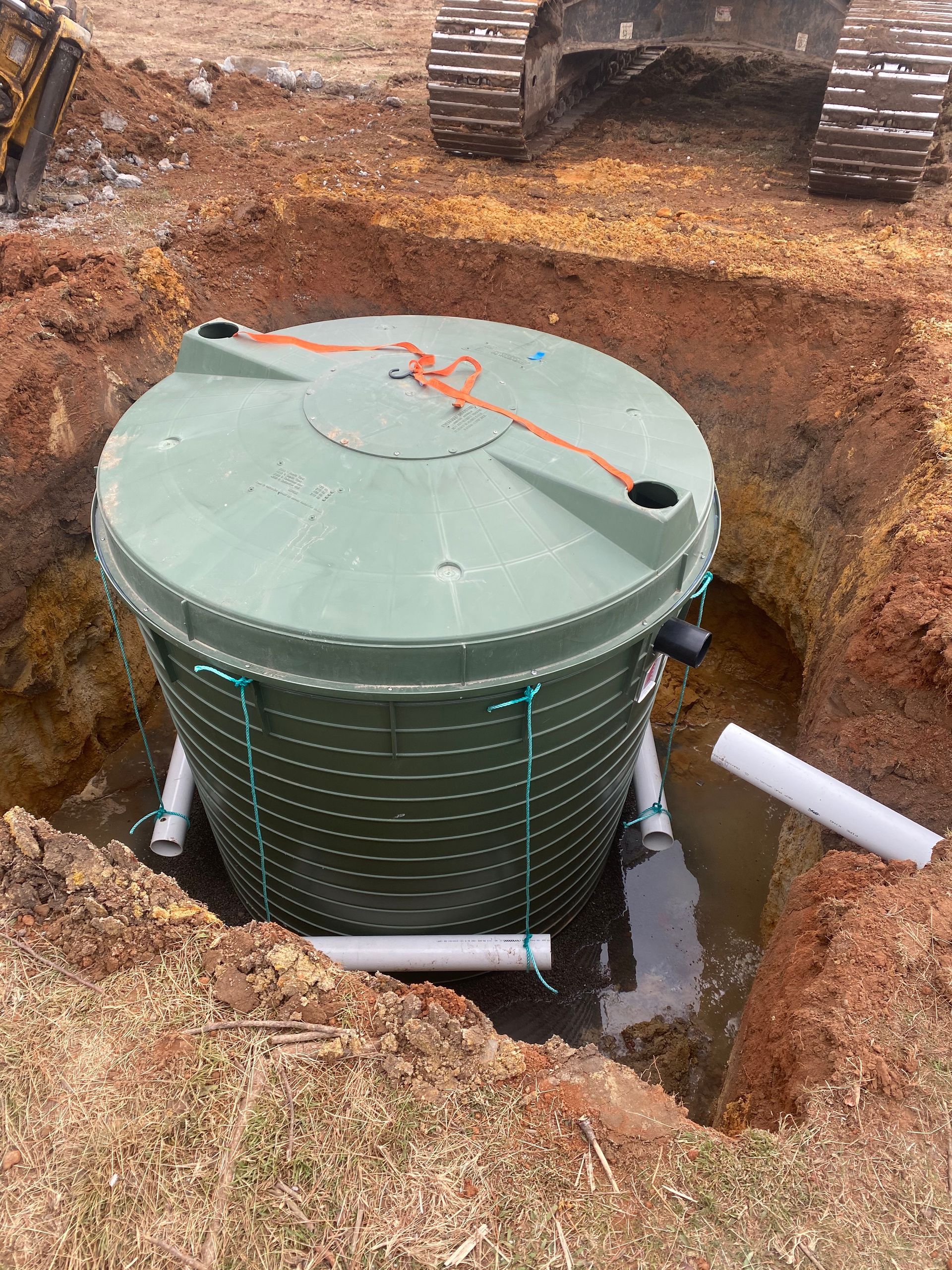 A Man Is Pumping Water Into A Septic Tank With A Hose — Aquafix Plumbing Services in Bowral, NSW