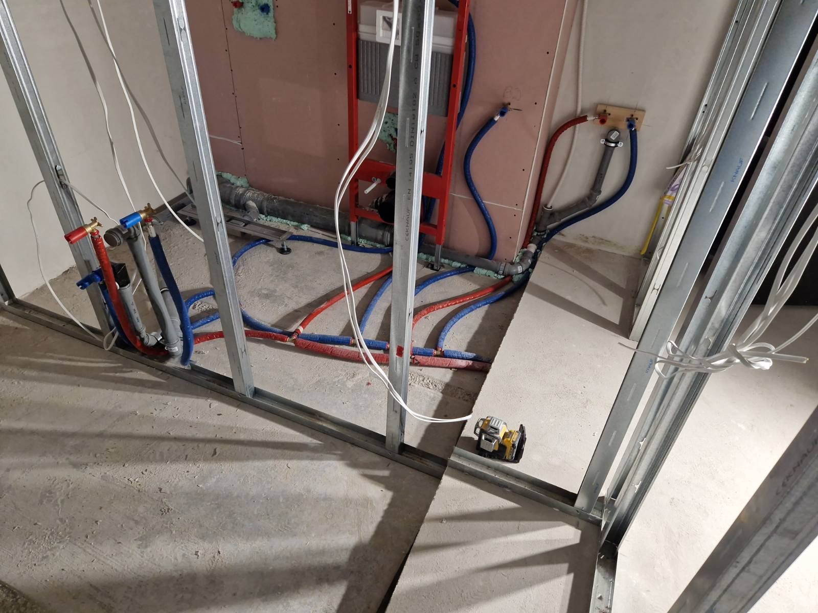 Santechnikos vamzdynų ir elektros instaliacijos išvedžiojimas ant paruošto pagrindo, prieš betono liejimą.