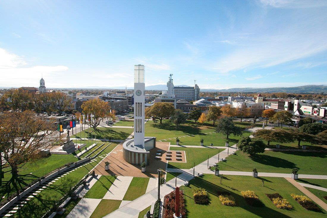 An aerial view of a park with a clock tower in the middle.