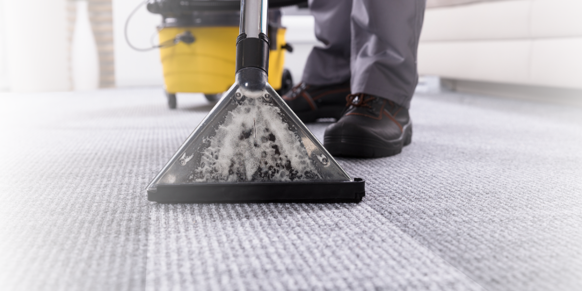 Person cleaning a rug with a vacuum cleaner - Total Clean Professional Carpet Cleaning Services