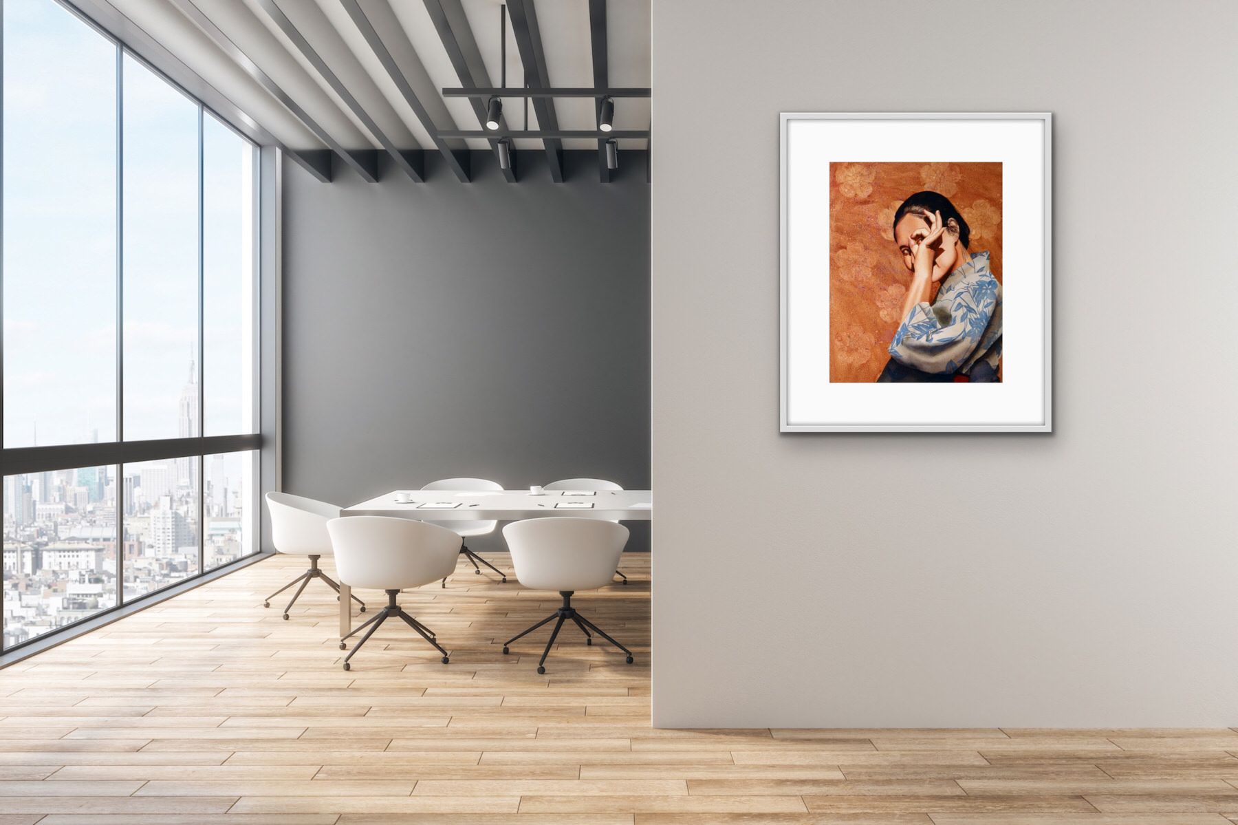 Modern office interior with large windows and a framed portrait on a gray wall