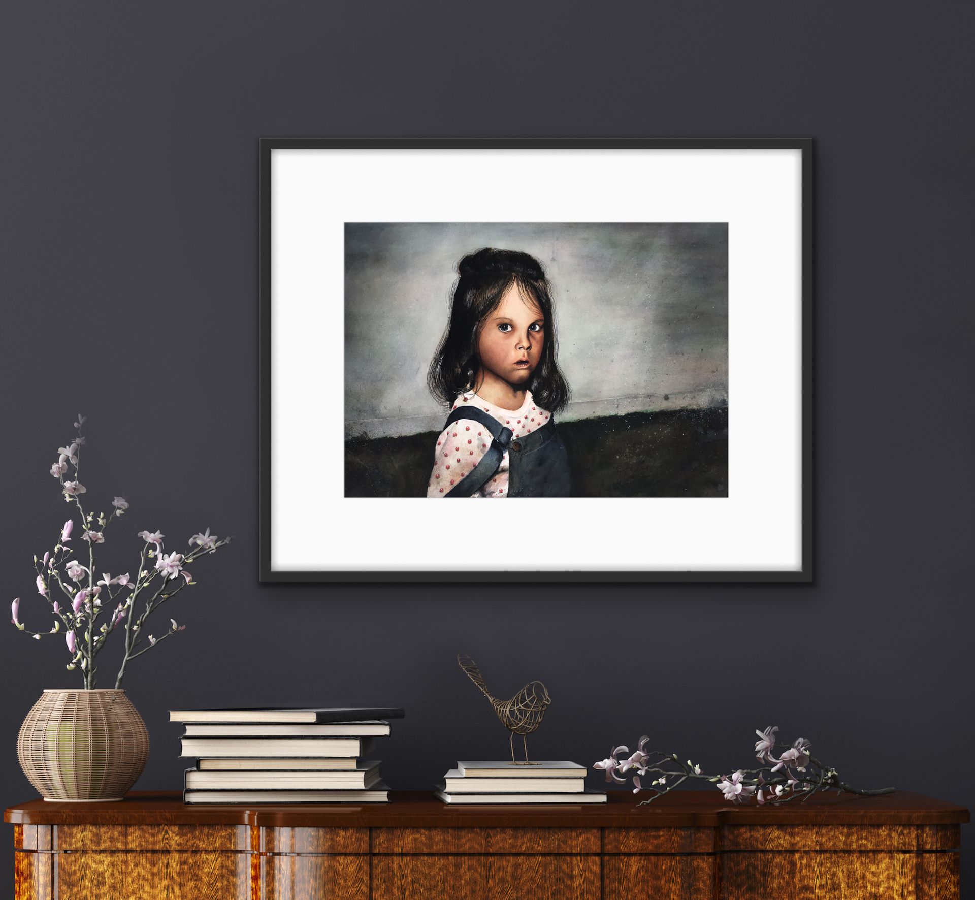 Framed portrait above a wooden console table with books and a vase in a dark room