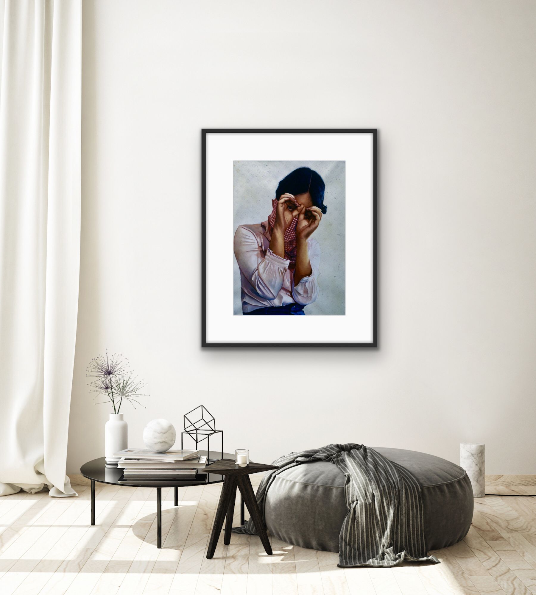Framed portrait above a low bench in a minimalist room with white walls, curtains, and a gray throw blanket.