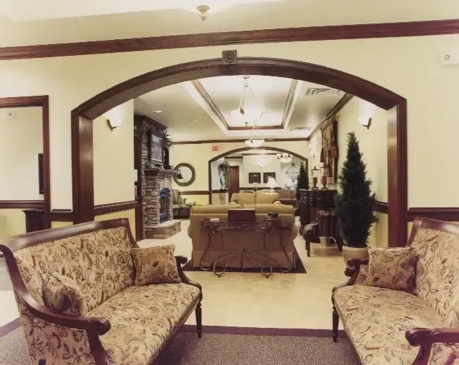 Elegant lounge with patterned sofas, a dining table, and a large arched opening