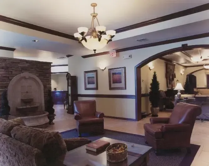 Elegant hotel lobby with stone fireplace, leather chairs, and warm chandelier lighting