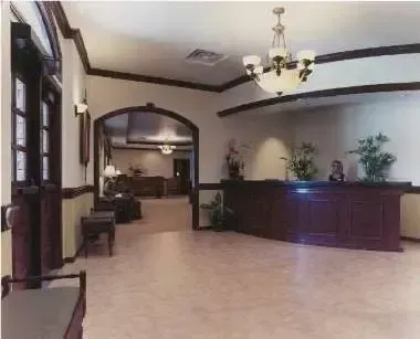 Elegant hotel lobby with chandelier, dark wood reception desk, and arched doorway