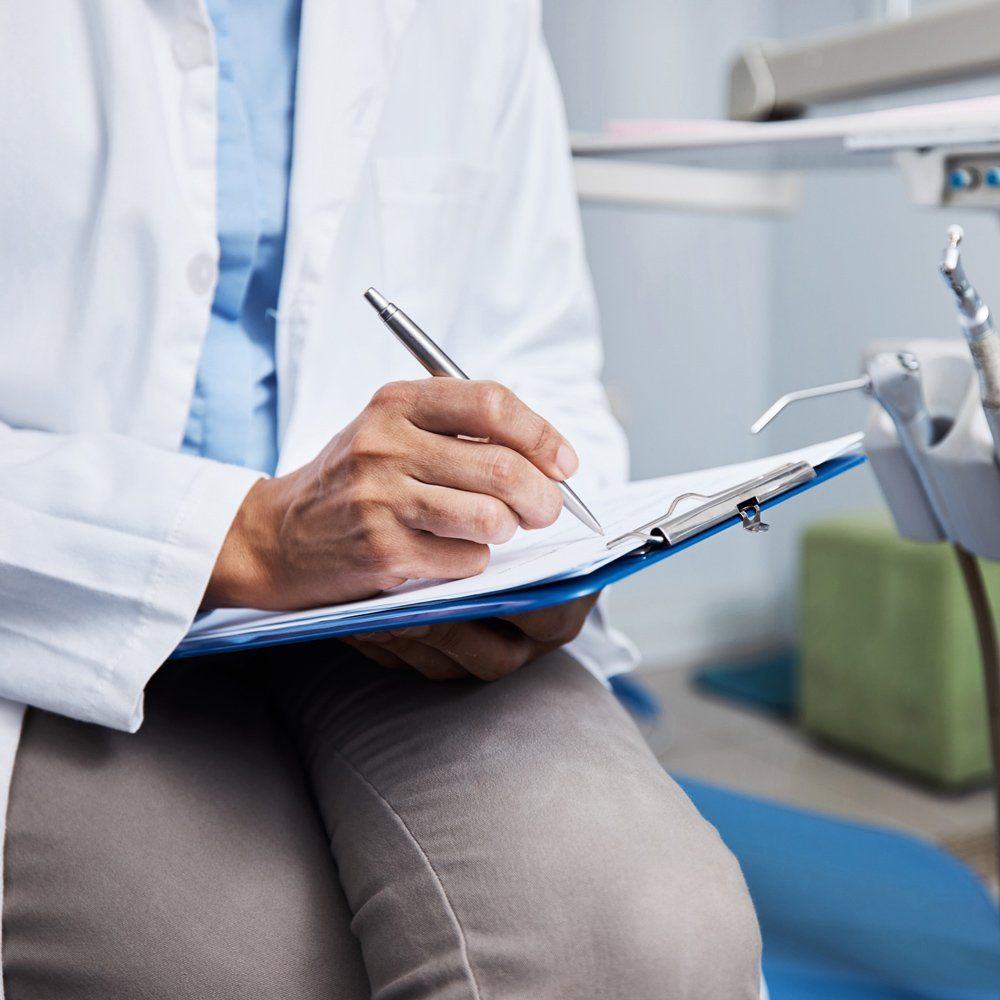 Dentist Filling Up Patient Form — Sarasota, FL — Sterling Dental