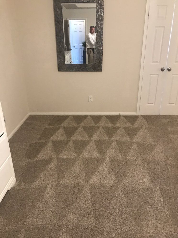 A room with a carpeted floor and a mirror on the wall.