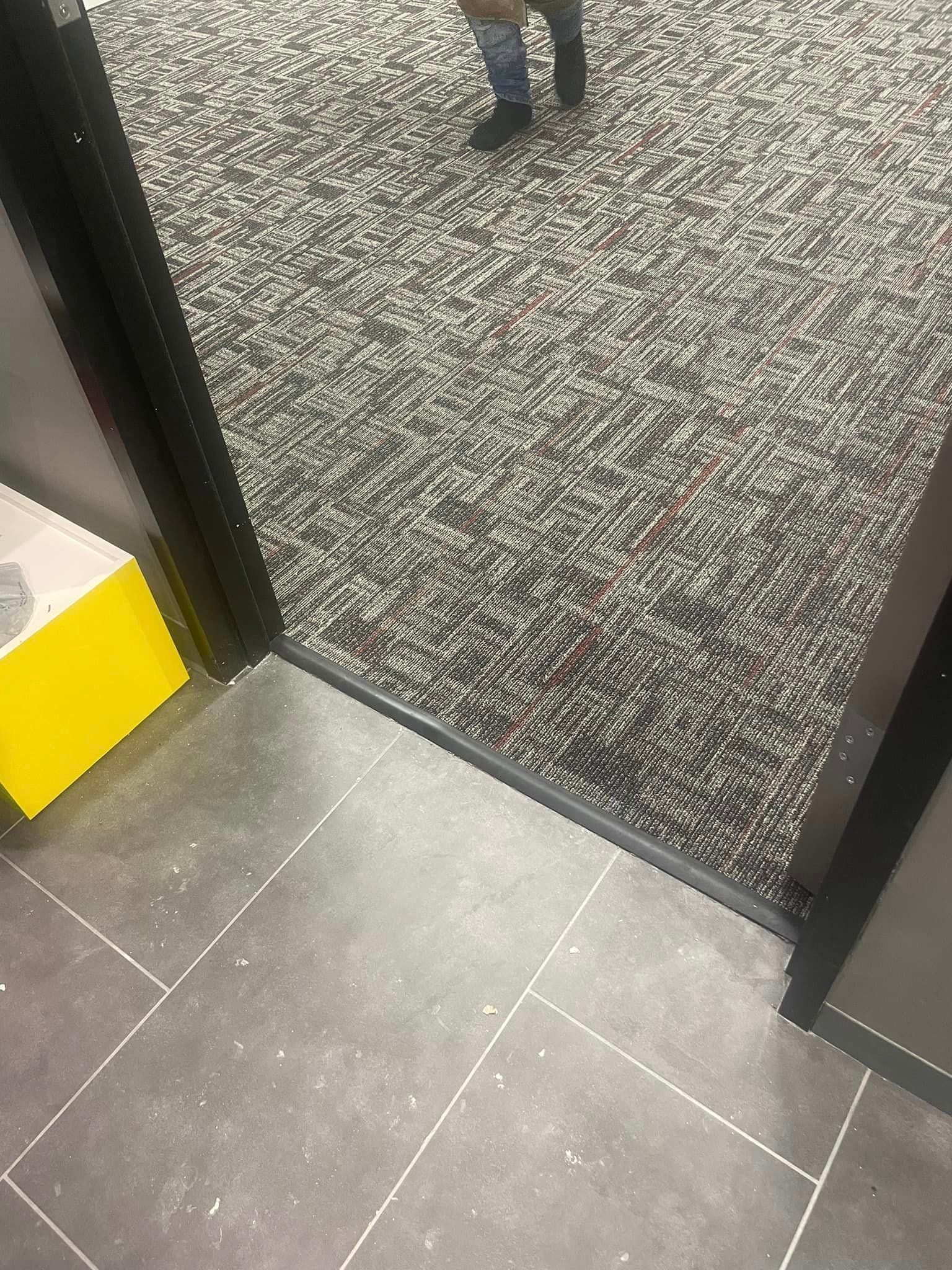 A person is standing on a tiled floor next to a door.