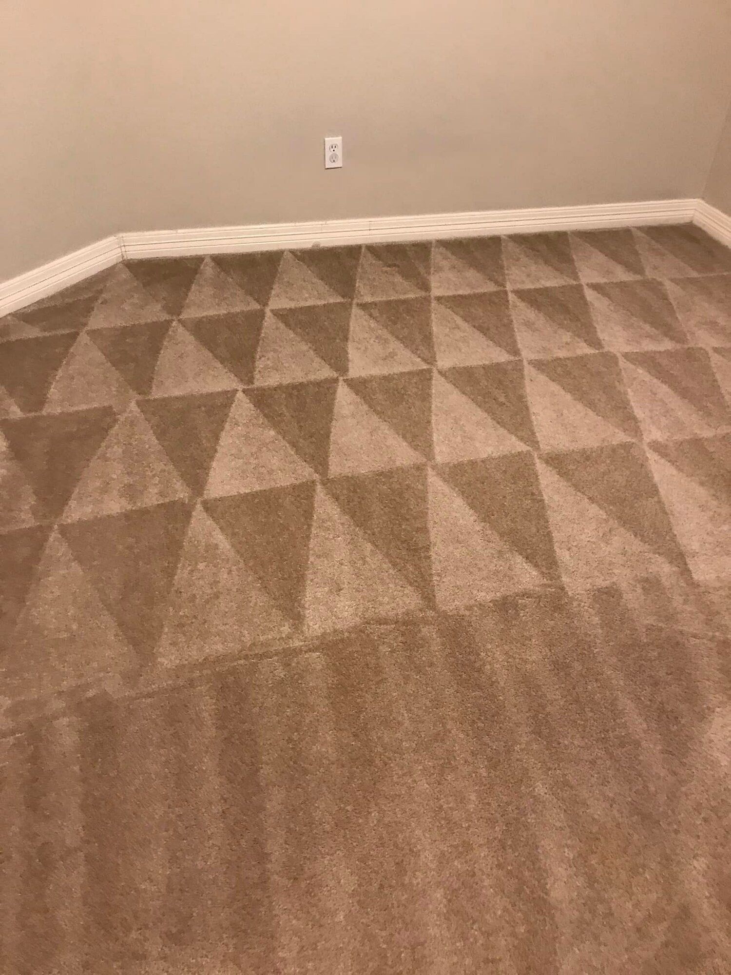A brown carpet in a room with a pattern of triangles on it.