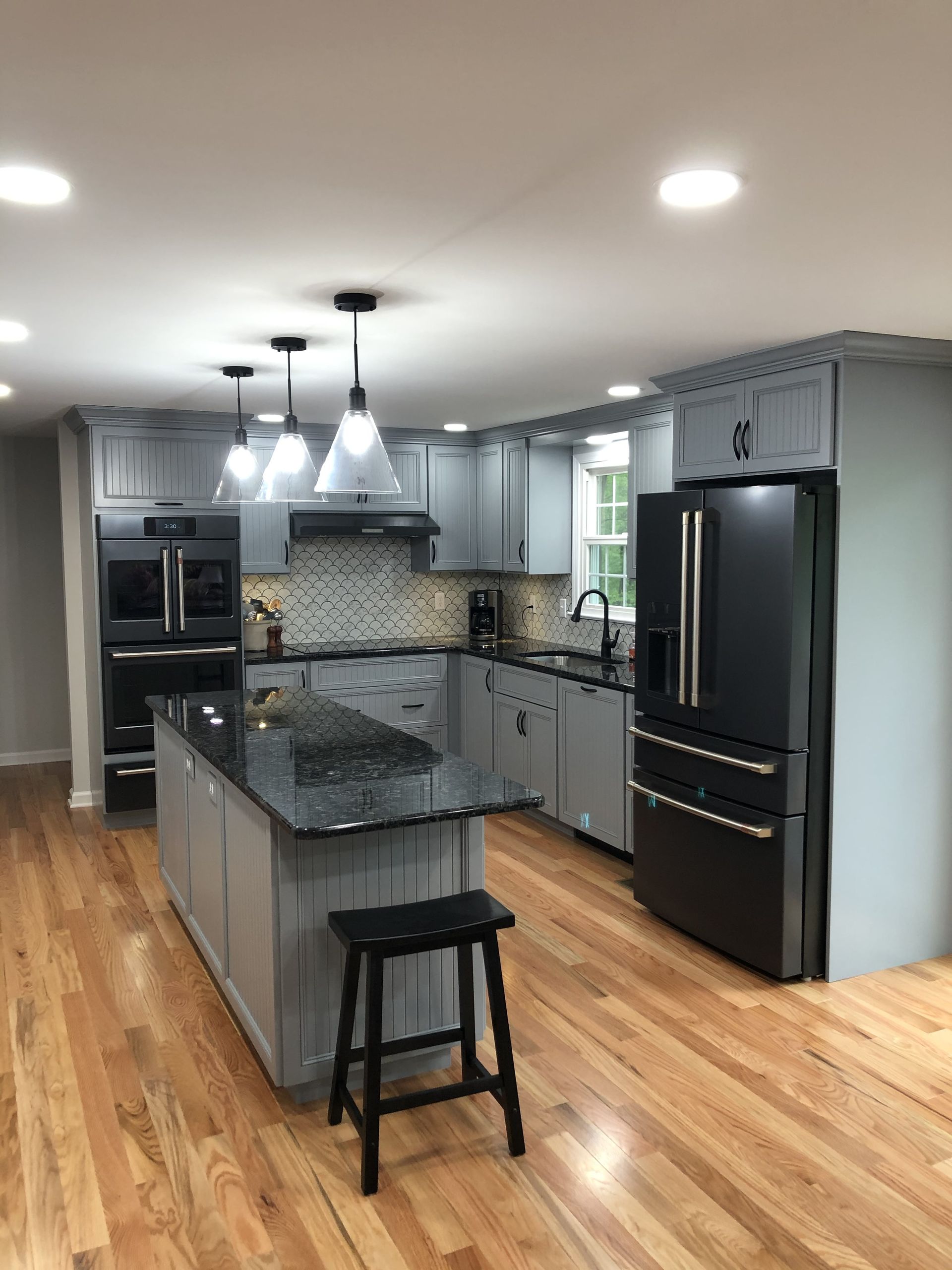 A Kitchen with Hardwood Floors , Gray Cabinets , Black Appliances and A Black Refrigerator | York, PA | C&K Cabinetry
