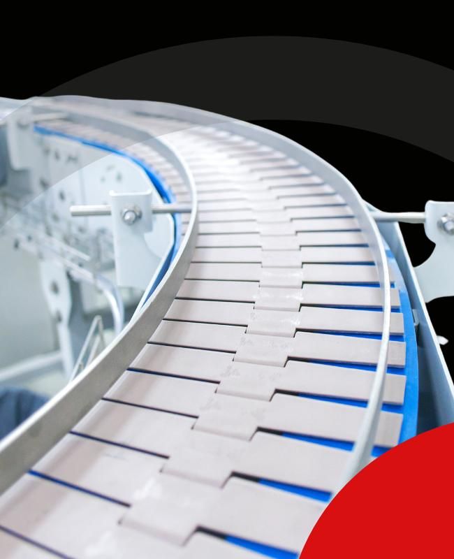 Cinta transportadora curva de color blanco en un entorno industrial.