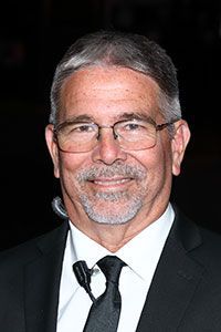A man with glasses and a beard is wearing a suit and tie.