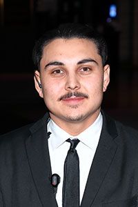 A man in a suit and tie is looking at the camera.
