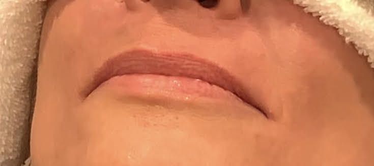 A close up of a woman 's forehead with her eyes closed.