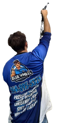 Technician in blue shirt cleaning a window with a pressure-washing wand