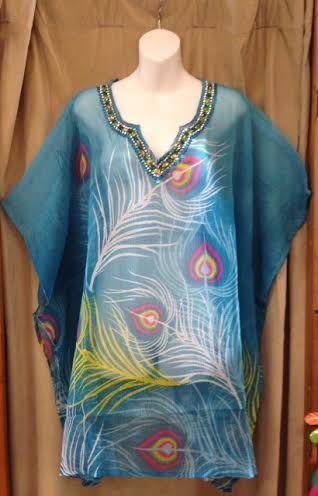Blue sheer tunic with multicolor feather-like print and beaded neckline on a mannequin