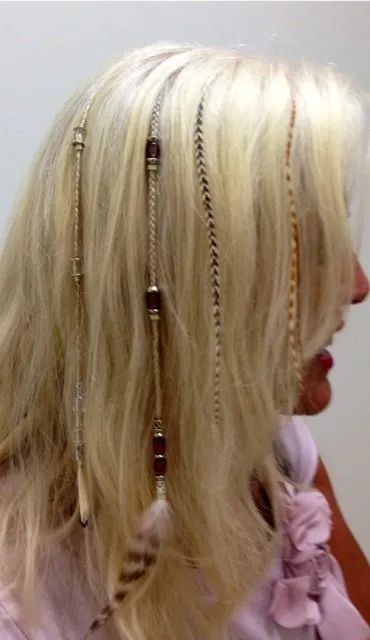 Blonde hair with thin braided sections and beads, shown in side profile against a plain background.