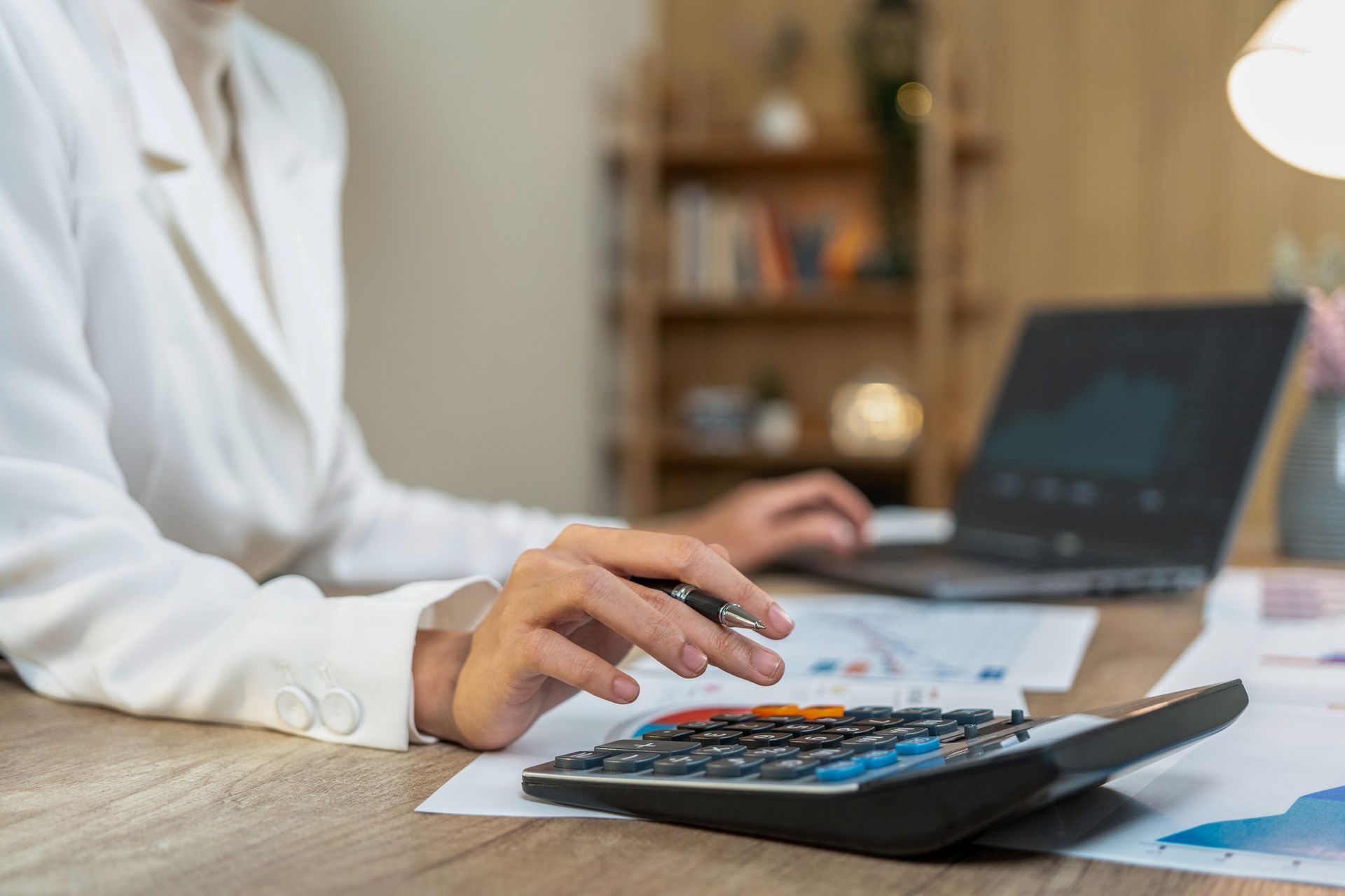 A person is using a calculator on a table.