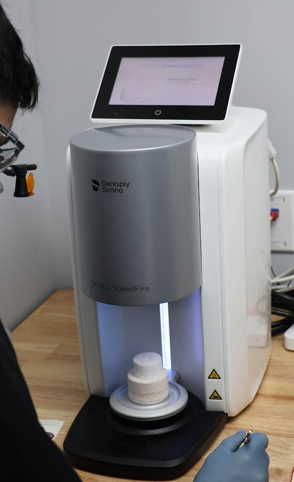 A person is using a machine on a wooden table.