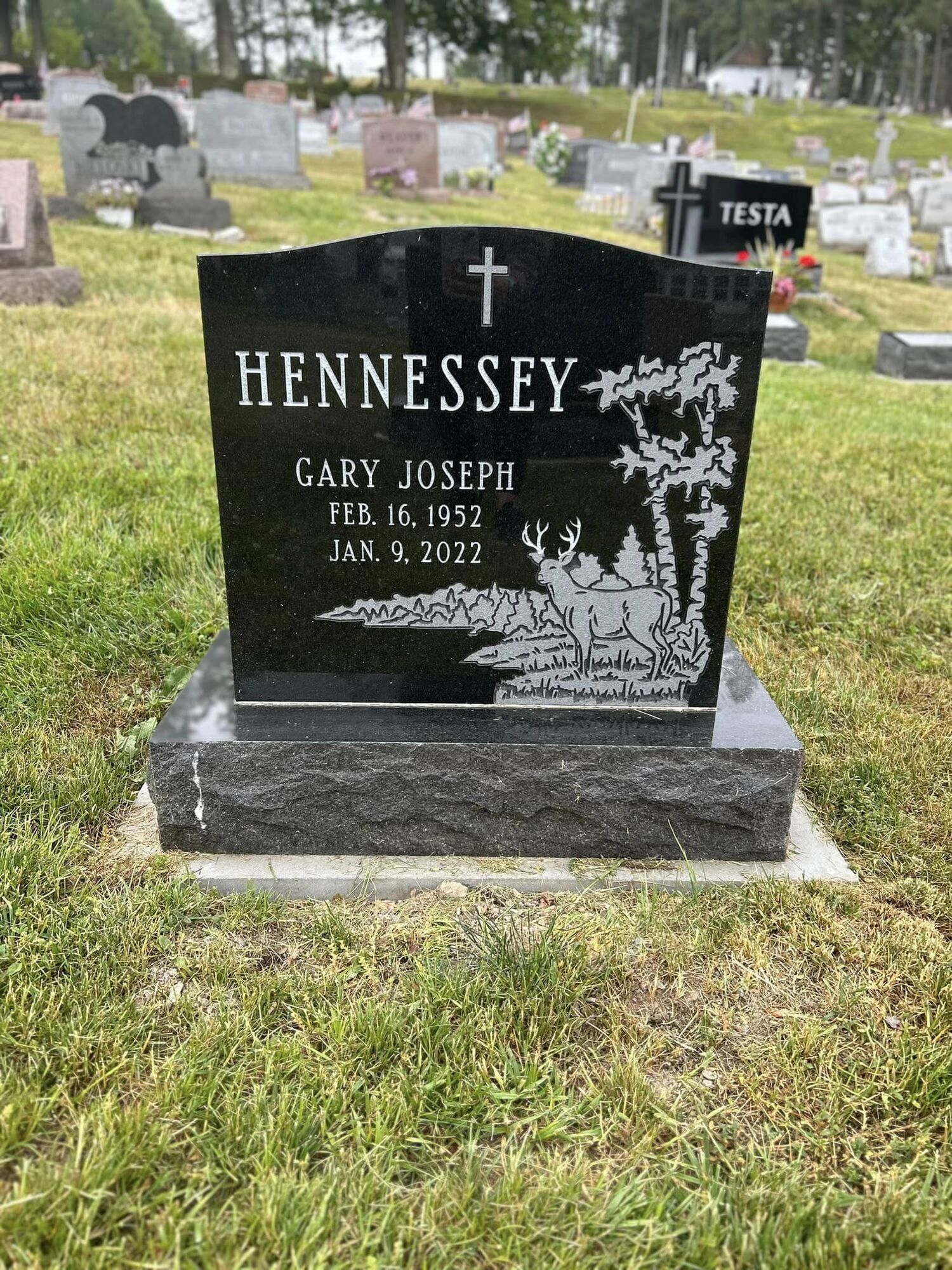 Black granite headstone in a cemetery; engraved with