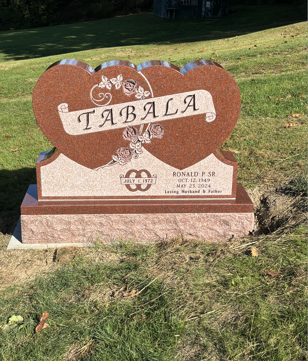 A red heart-shaped tombstone with the name