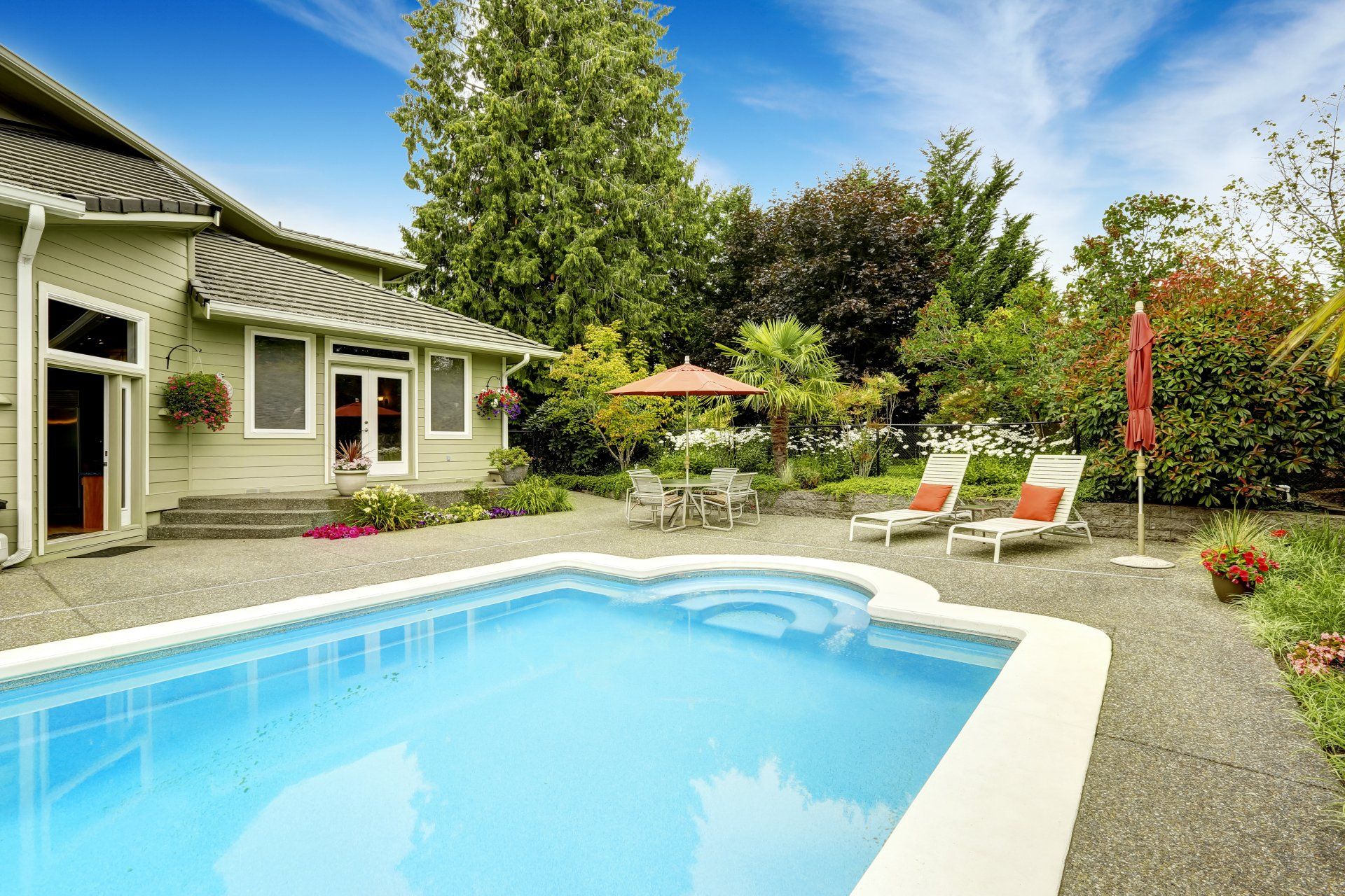 Il y a une grande piscine dans la cour d une maison.
