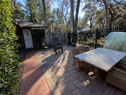 Backyard patio with table, chairs, brick paving, and a shed.