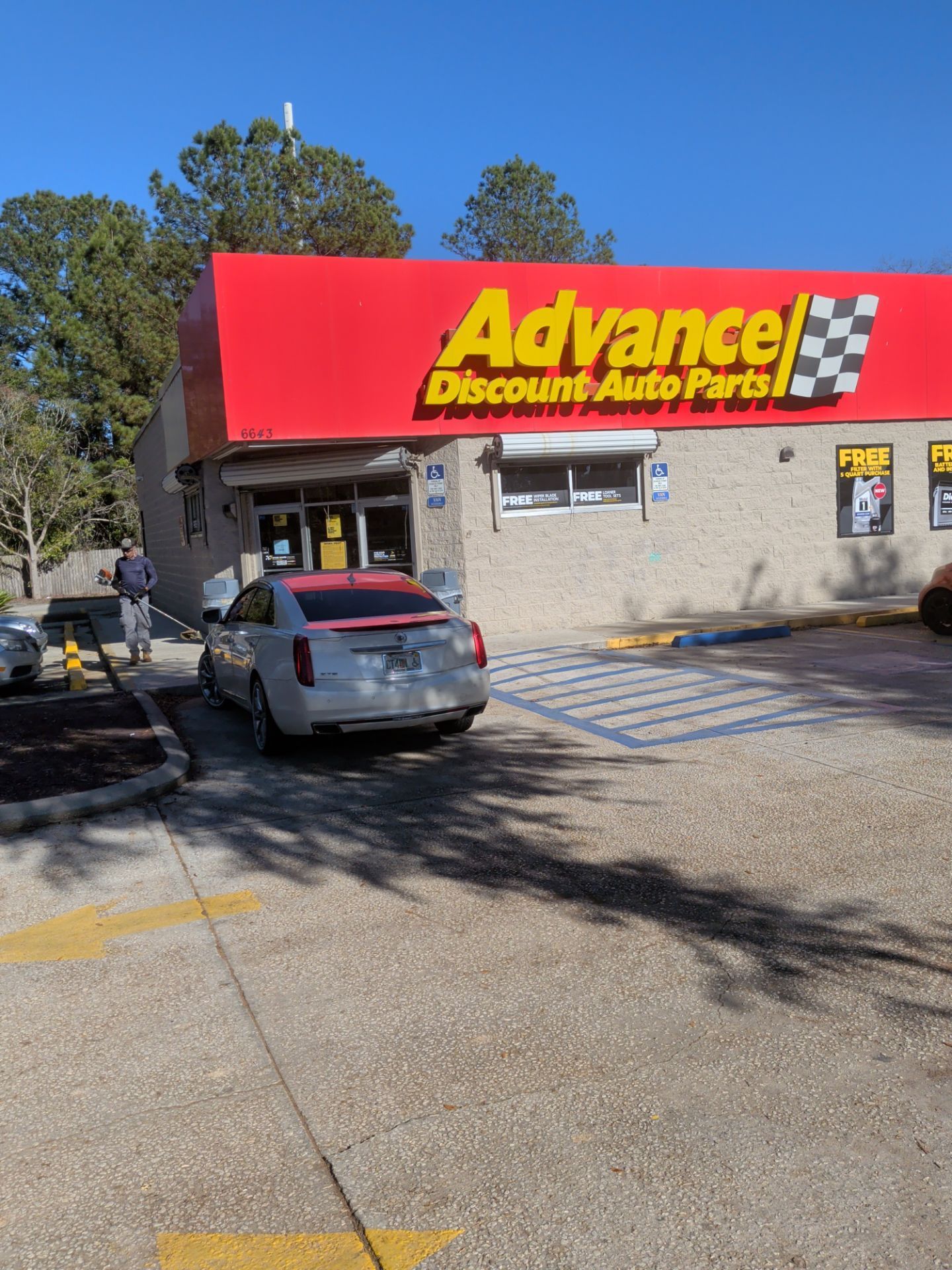 Advance Discount Auto Parts store exterior, with car in front; person walking toward entrance.