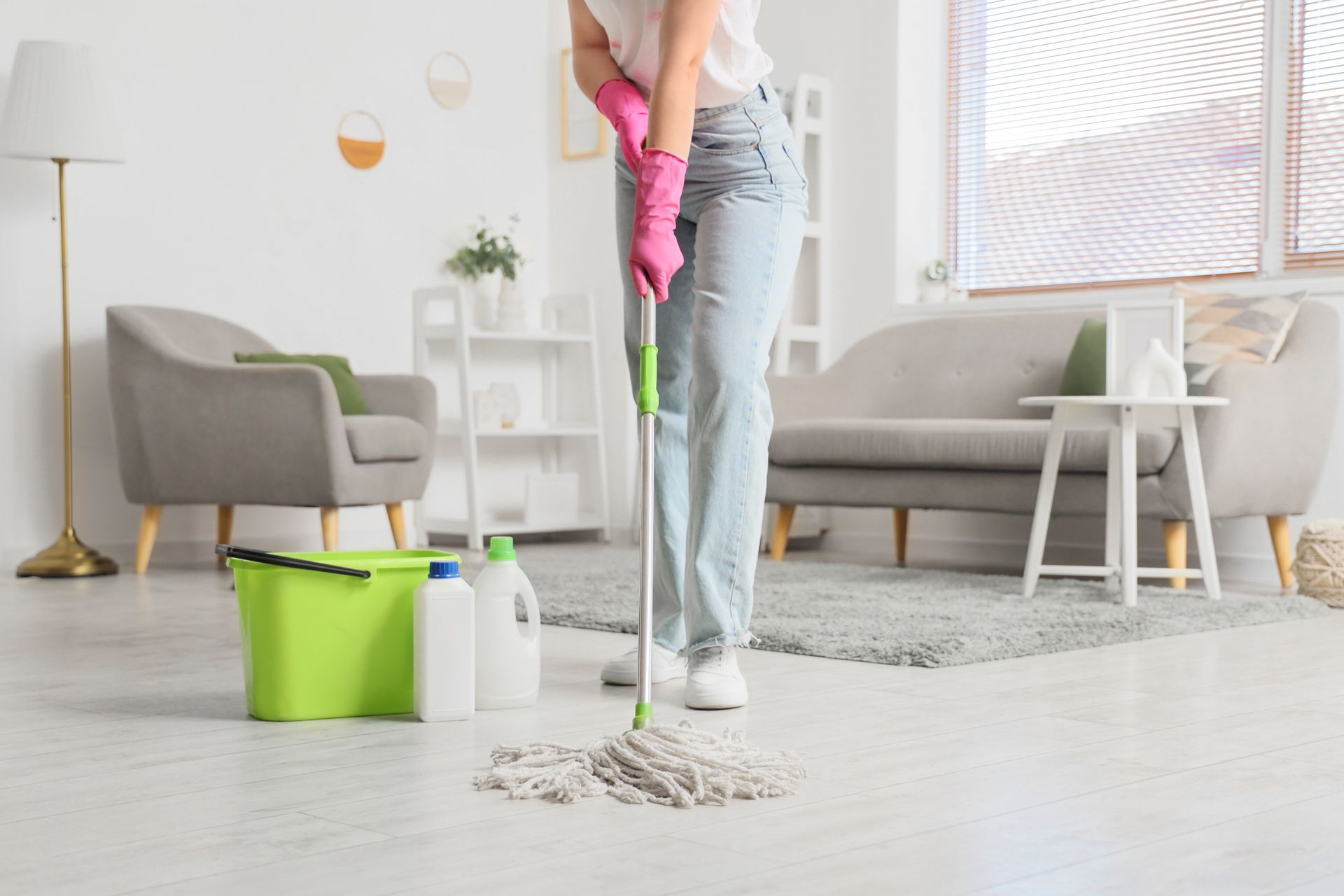 Cleaning staff mopping a tiled floor, one carrying a caddy of supplies and gloves